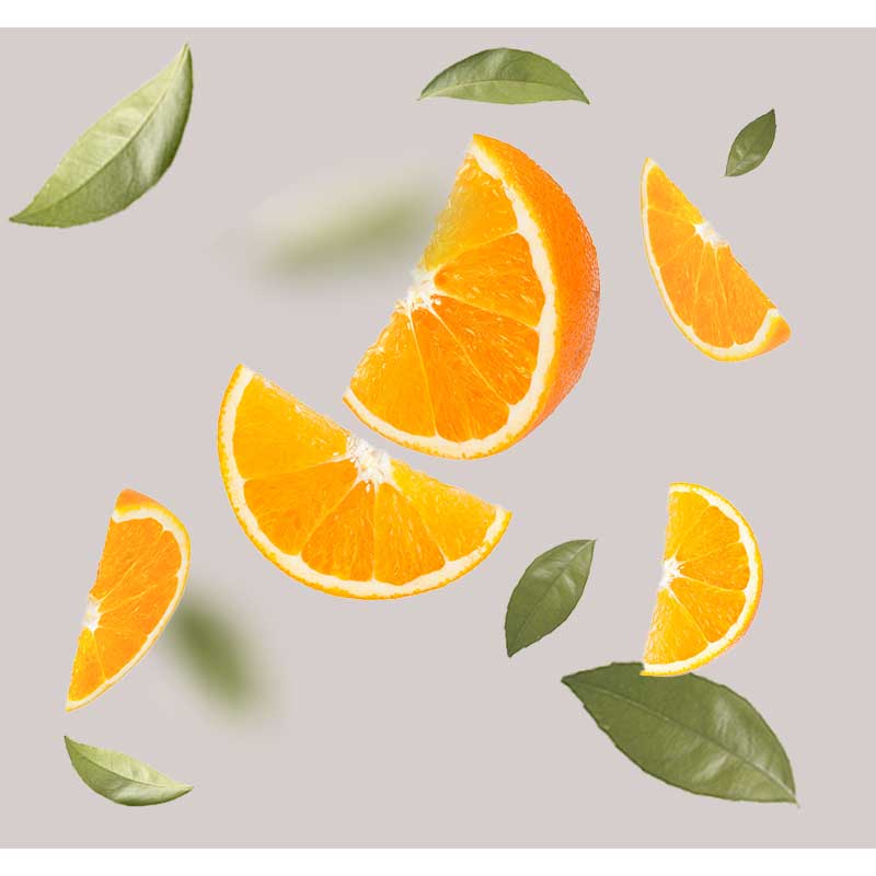 Apfelsine Scheiben von Apfelsine mit grünen Blättern auf grauem Hintergrund, symbolisierend den erfrischenden Duft des Cleansing & Refreshing Foam von RAU Cosmetics.