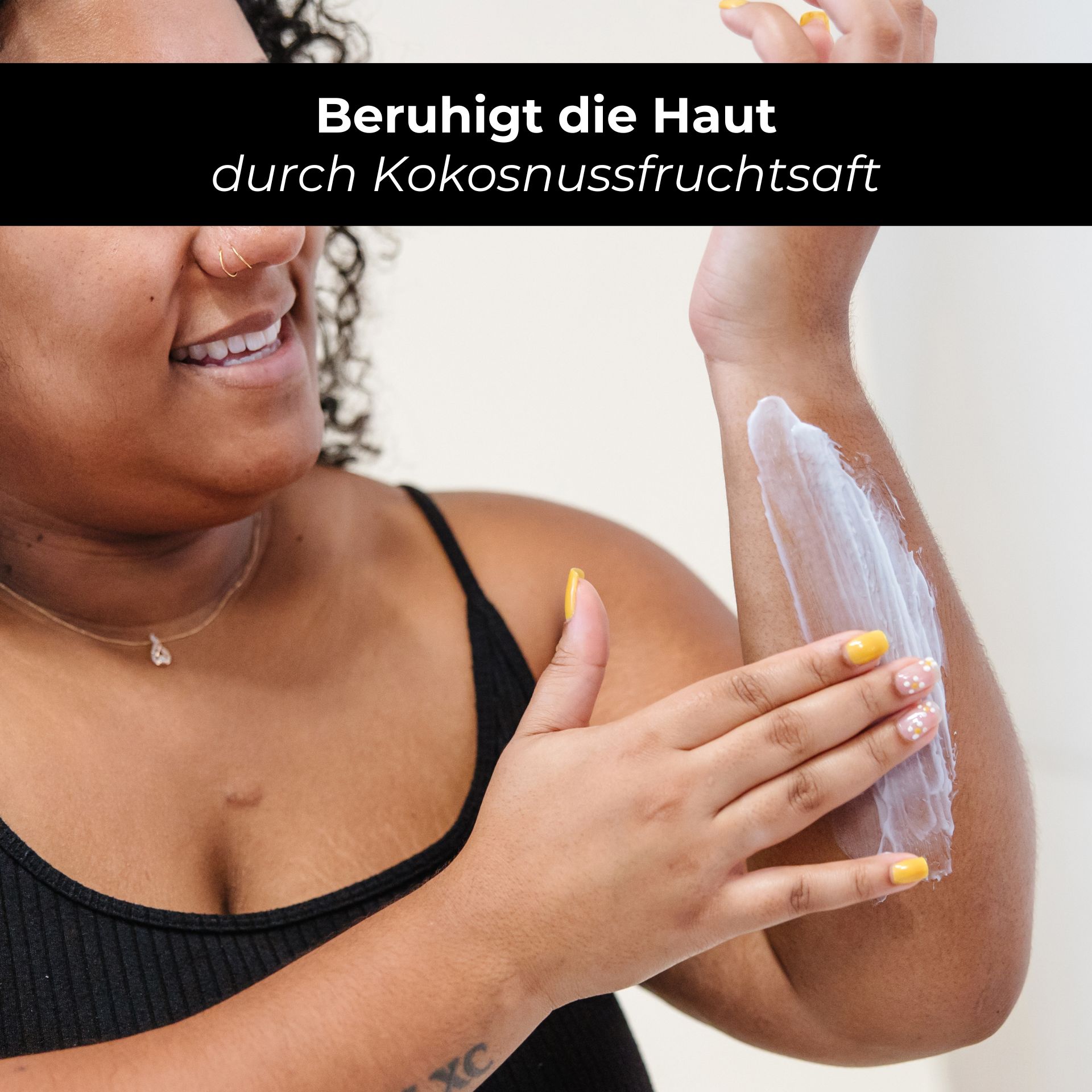 RAU Eternal Moist Body Lotion 500 ml - Intensive Feuchtigkeit für streichelzarte Haut Frau mit lockigem Haar trägt RAU Eternal Moist Body Lotion auf ihren Arm auf, betont die beruhigende Wirkung durch Kokosnussfruchtsaft.